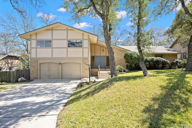 view of front of house with driveway, a front lawn, fence, an attached garage, and brick siding