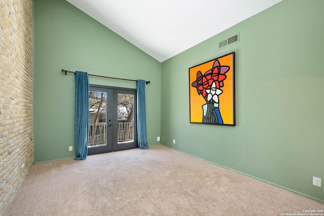 carpeted empty room featuring visible vents, french doors, and high vaulted ceiling