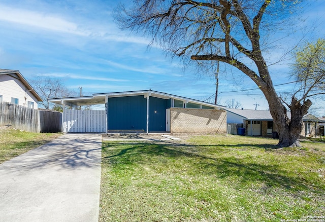 exterior space featuring an attached carport, a front lawn, driveway, and fence