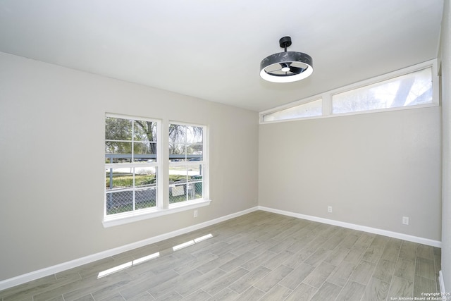 unfurnished room with light wood-type flooring, baseboards, and plenty of natural light