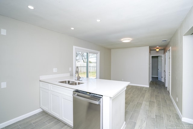 kitchen with a peninsula, a sink, light countertops, white cabinets, and stainless steel dishwasher