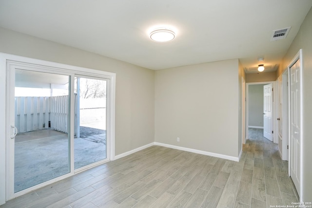 unfurnished room featuring baseboards, visible vents, and light wood finished floors