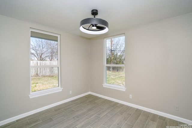 unfurnished room featuring baseboards and wood tiled floor