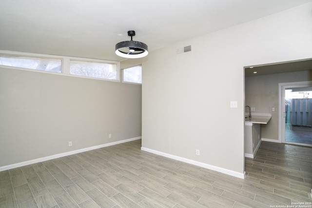 unfurnished room with visible vents, baseboards, and wood finish floors