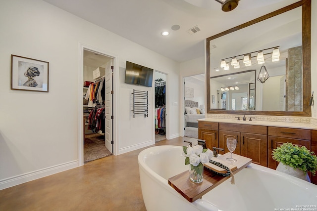 full bathroom with a freestanding tub, visible vents, vanity, concrete flooring, and a spacious closet