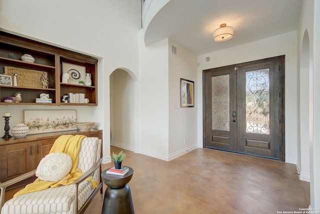 entryway featuring arched walkways, visible vents, french doors, and baseboards