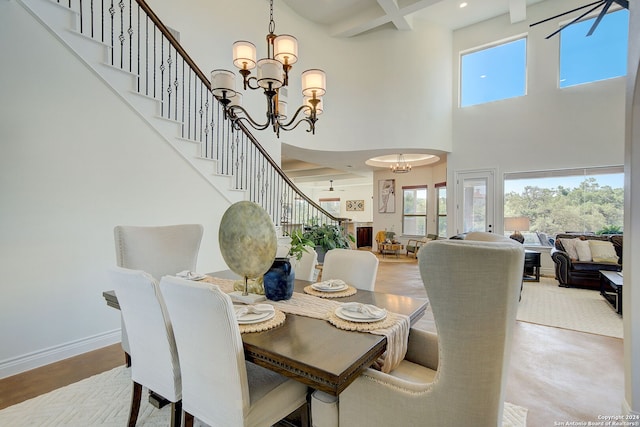 dining area featuring baseboards, beamed ceiling, stairs, an inviting chandelier, and a towering ceiling