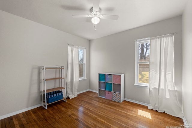 misc room featuring a wealth of natural light, baseboards, a ceiling fan, and wood-type flooring