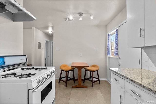 kitchen with light stone counters, visible vents, white cabinets, white gas range, and backsplash