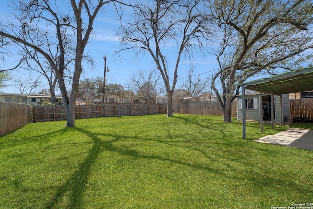 view of yard with an outdoor structure, a fenced backyard, and a patio