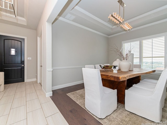 dining area with baseboards, a tray ceiling, and ornamental molding