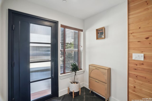 doorway to outside featuring baseboards