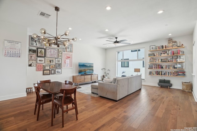 interior space featuring recessed lighting, ceiling fan with notable chandelier, visible vents, and wood-type flooring