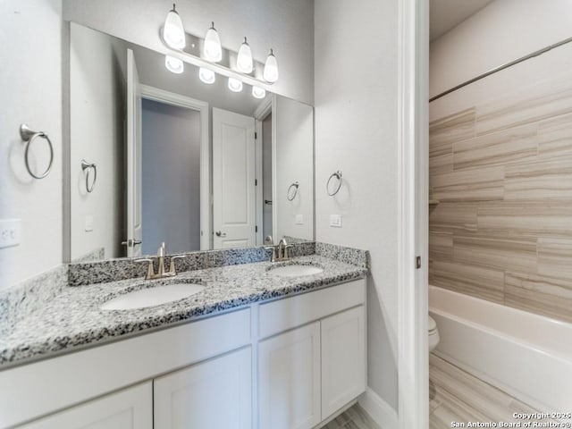 full bathroom featuring a sink, toilet, and double vanity