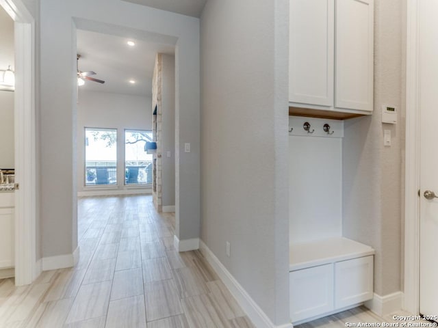 mudroom featuring baseboards, light wood-style floors, and ceiling fan