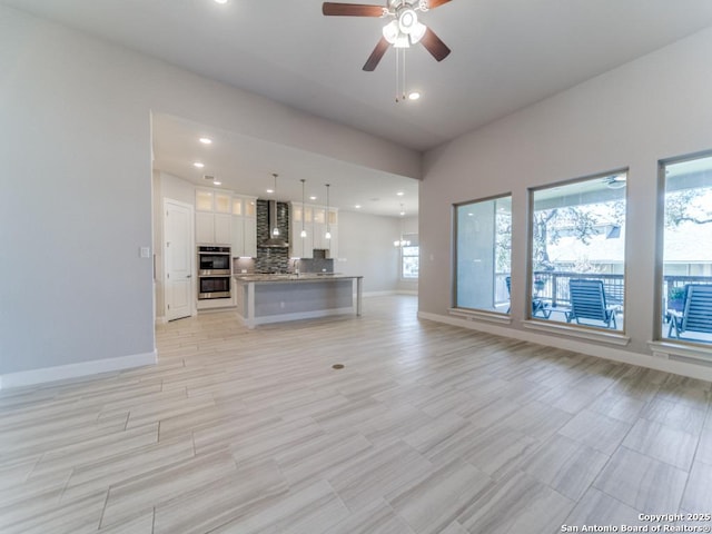 unfurnished living room featuring recessed lighting, baseboards, and ceiling fan