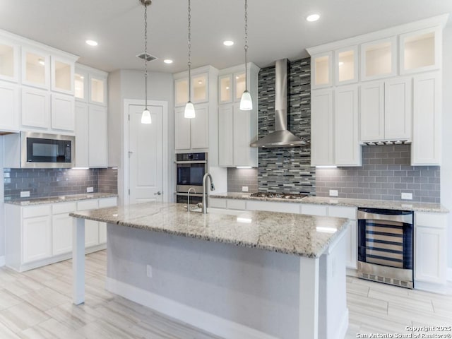 kitchen featuring visible vents, stainless steel appliances, wine cooler, white cabinets, and wall chimney exhaust hood