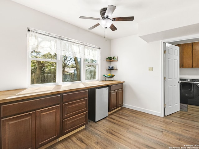 kitchen with refrigerator, washer / clothes dryer, light wood finished floors, and wood counters