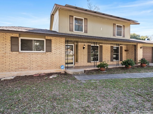 traditional home featuring an attached garage, brick siding, and covered porch