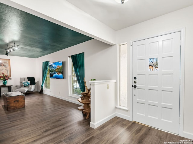 entrance foyer featuring dark wood-type flooring and baseboards