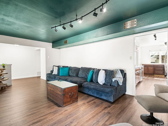 living area featuring visible vents and wood finished floors