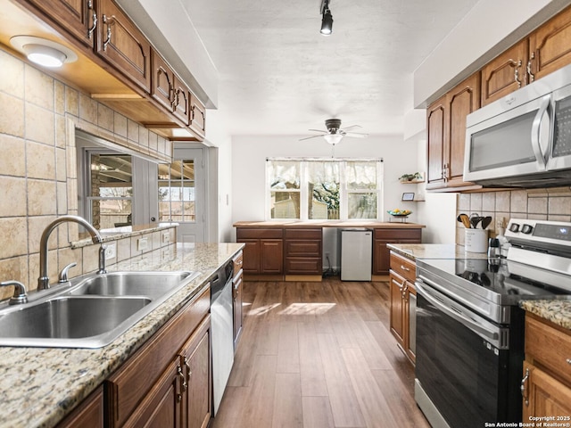 kitchen featuring tasteful backsplash, ceiling fan, dark wood finished floors, stainless steel appliances, and a sink