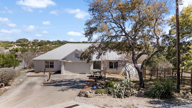 ranch-style house with concrete driveway, an attached garage, fence, and brick siding