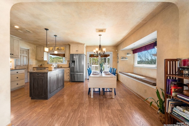 kitchen featuring visible vents, stainless steel fridge with ice dispenser, light wood-style floors, and a wealth of natural light