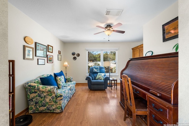 office area featuring visible vents, baseboards, wood finished floors, and a ceiling fan