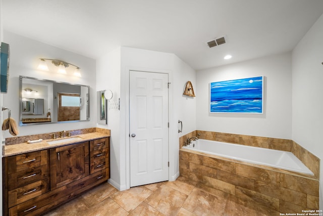 bathroom featuring a bath, visible vents, and vanity