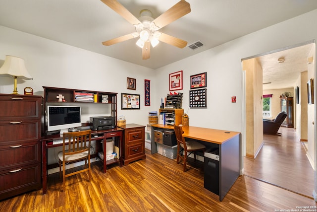 office space with baseboards, visible vents, dark wood-style flooring, and ceiling fan