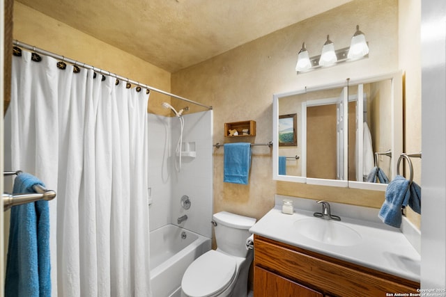 bathroom with vanity, toilet, a textured wall, and shower / bath combo