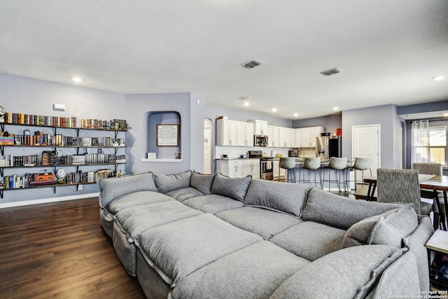 living area featuring recessed lighting, dark wood-style floors, visible vents, and baseboards