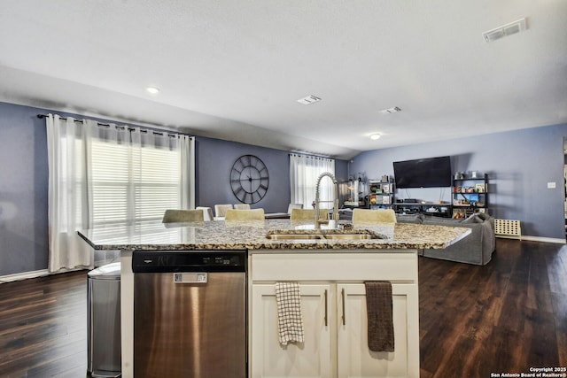 kitchen with visible vents, a sink, light stone counters, stainless steel dishwasher, and open floor plan