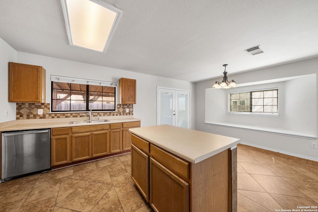 kitchen with a sink, tasteful backsplash, dishwasher, and a healthy amount of sunlight