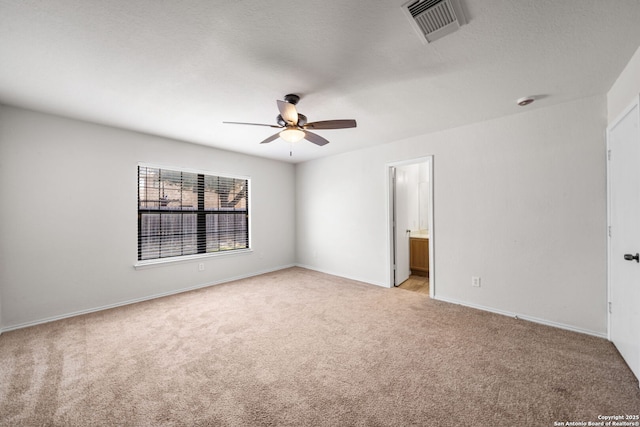 empty room with baseboards, light colored carpet, visible vents, and ceiling fan