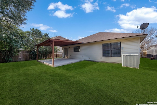 back of property with central AC unit, a patio area, a lawn, and a fenced backyard