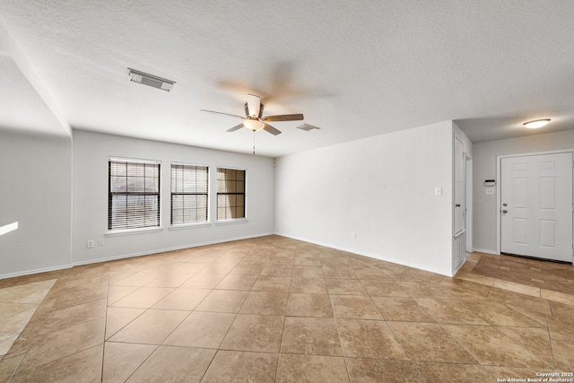 unfurnished room featuring visible vents, a textured ceiling, baseboards, and a ceiling fan