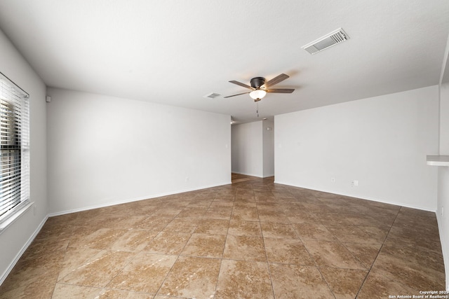 spare room featuring visible vents, baseboards, and ceiling fan