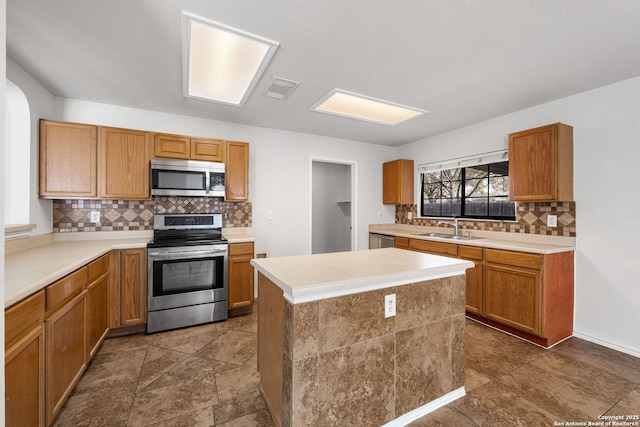 kitchen featuring visible vents, appliances with stainless steel finishes, light countertops, and a sink