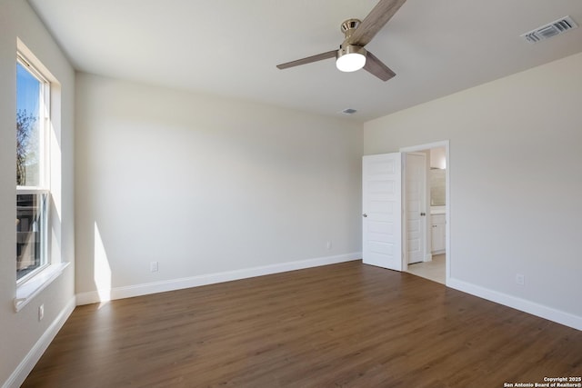 unfurnished room featuring visible vents, baseboards, wood finished floors, and a ceiling fan