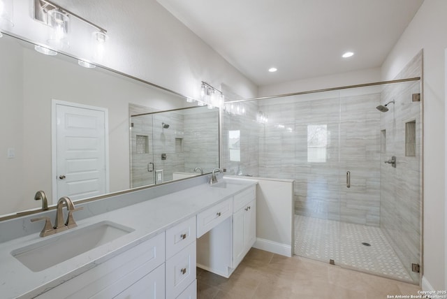 bathroom with tile patterned flooring, double vanity, a shower stall, and a sink