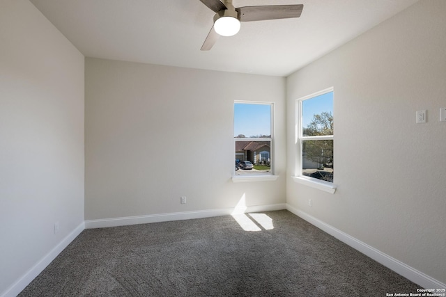 carpeted empty room with a ceiling fan and baseboards