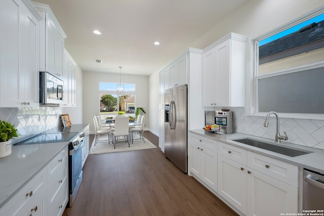 kitchen featuring appliances with stainless steel finishes, white cabinetry, and a sink