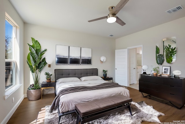 bedroom featuring visible vents, baseboards, a ceiling fan, and wood finished floors