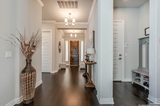 entryway featuring baseboards, visible vents, dark wood finished floors, ornamental molding, and a chandelier