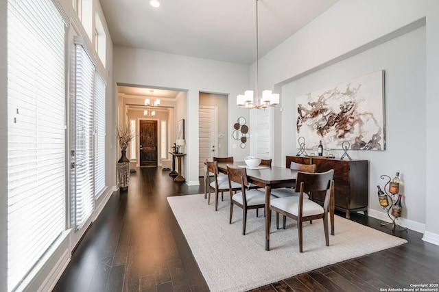 dining space with a chandelier, recessed lighting, dark wood finished floors, and baseboards