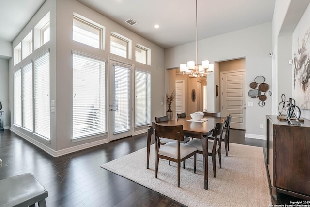 dining space featuring a wealth of natural light, a notable chandelier, baseboards, and dark wood-style flooring