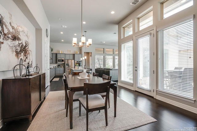 dining room with visible vents, dark wood-type flooring, recessed lighting, an inviting chandelier, and baseboards