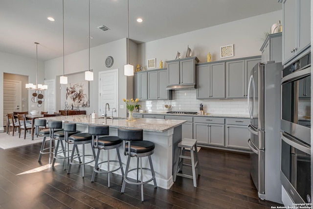 kitchen featuring tasteful backsplash, gray cabinetry, and a sink